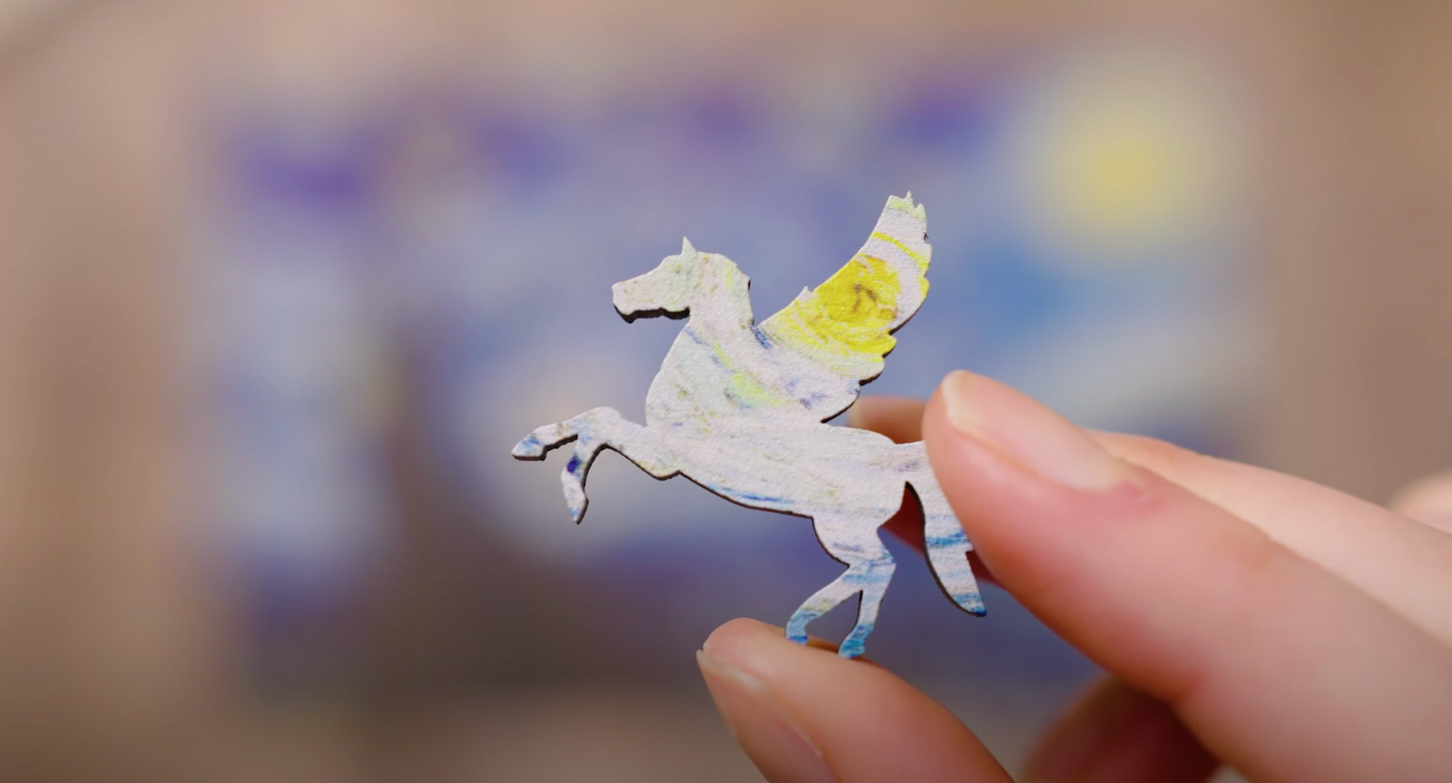 Hand holding pastel blue unicorn puzzle piece 